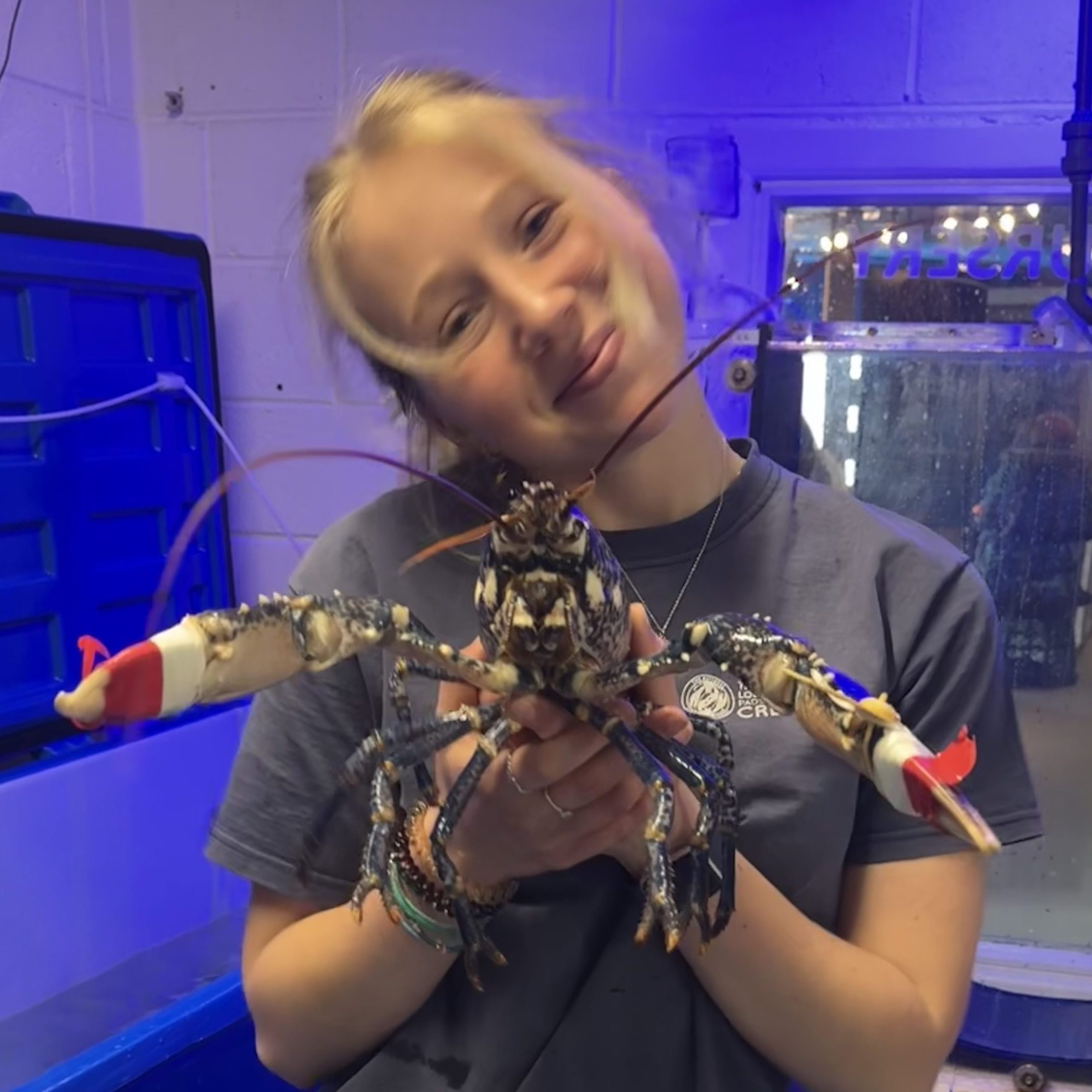 Placement student Ruby smiling and holding a berried hen lobster